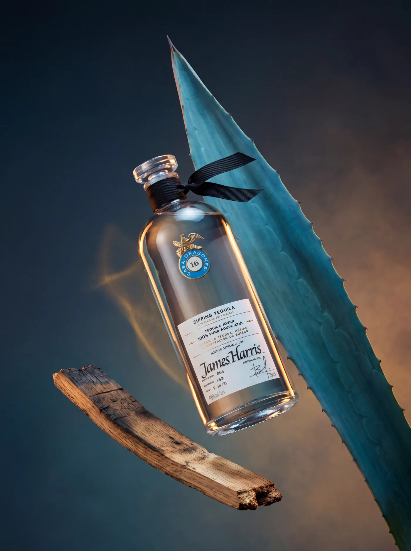 Casa Dragones tequila bottle propped against a blue agave leaf and charred wood