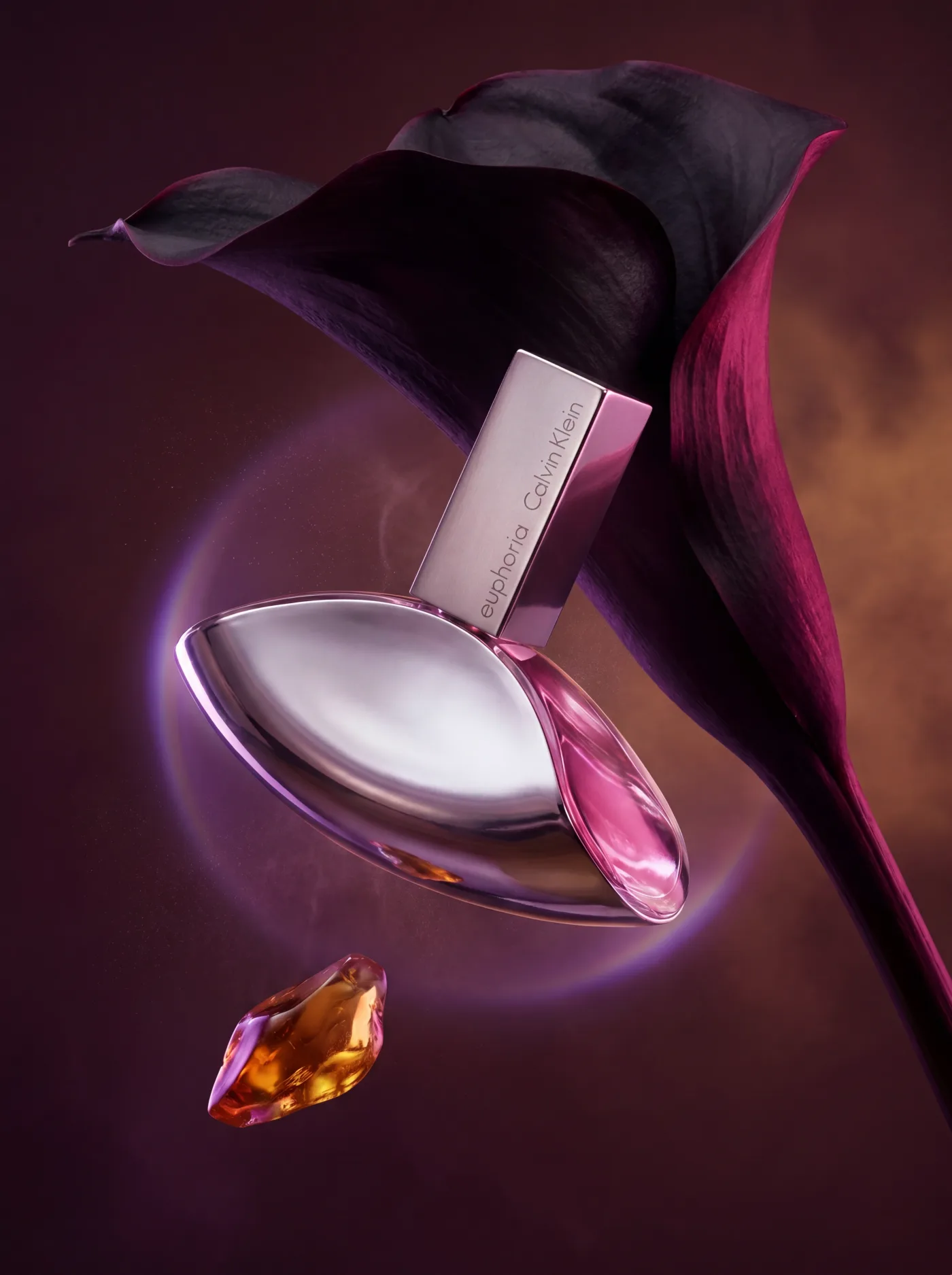 Calvin Klein Euphoria perfume bottle beside a dark calla lily and amber gemstone